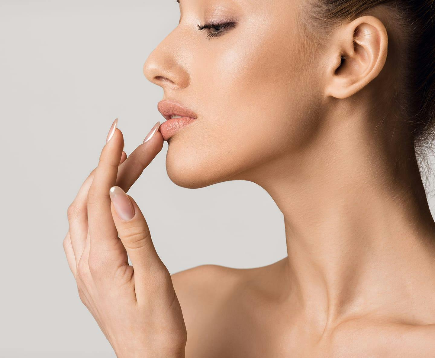 side profile of woman touching her bottom lip