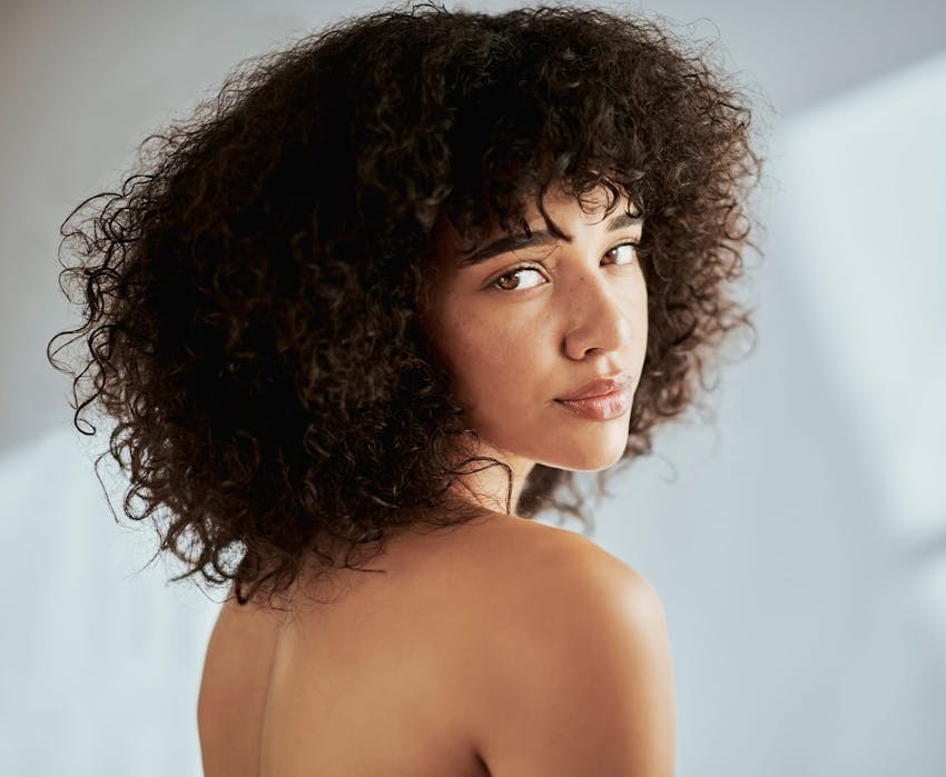 woman with afro looking over her shoulder