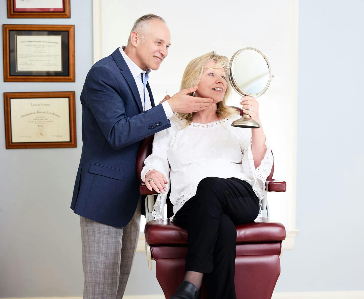 Dr. Fechner showing client her chin in handheld mirror