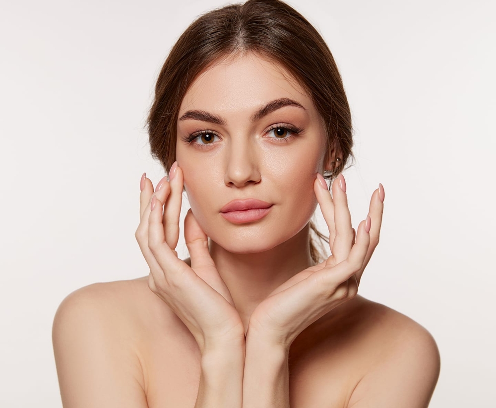 woman touching her cheek bones