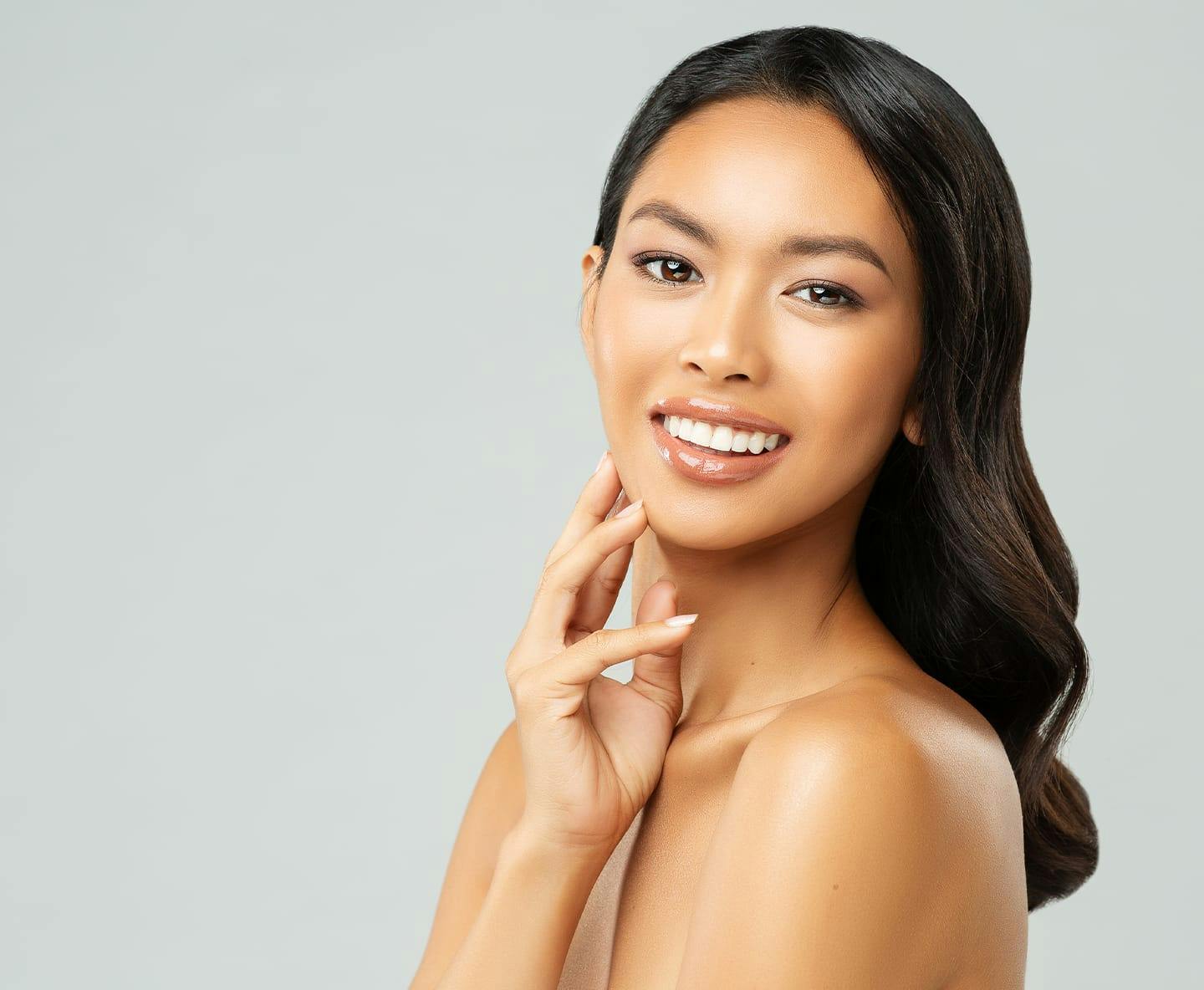 woman looking over her shoulder with fingers touching her jaw