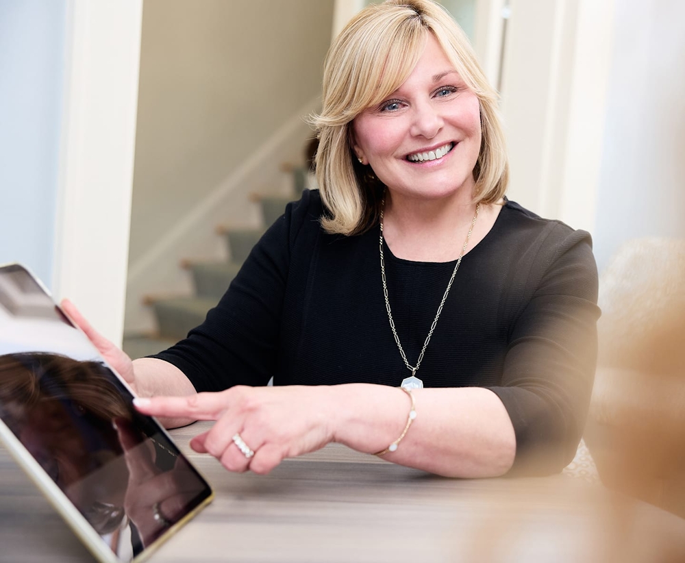 patient smiling and pointing to ipad