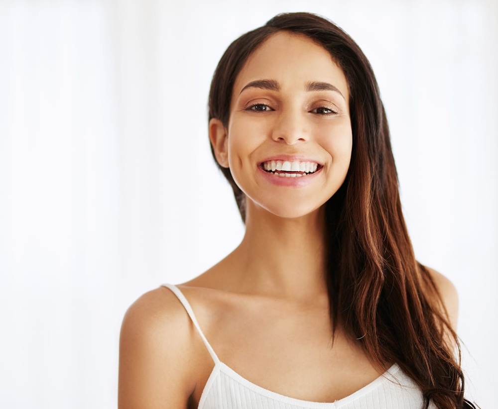 woman smiling with hair falling onto one side on her shoulder