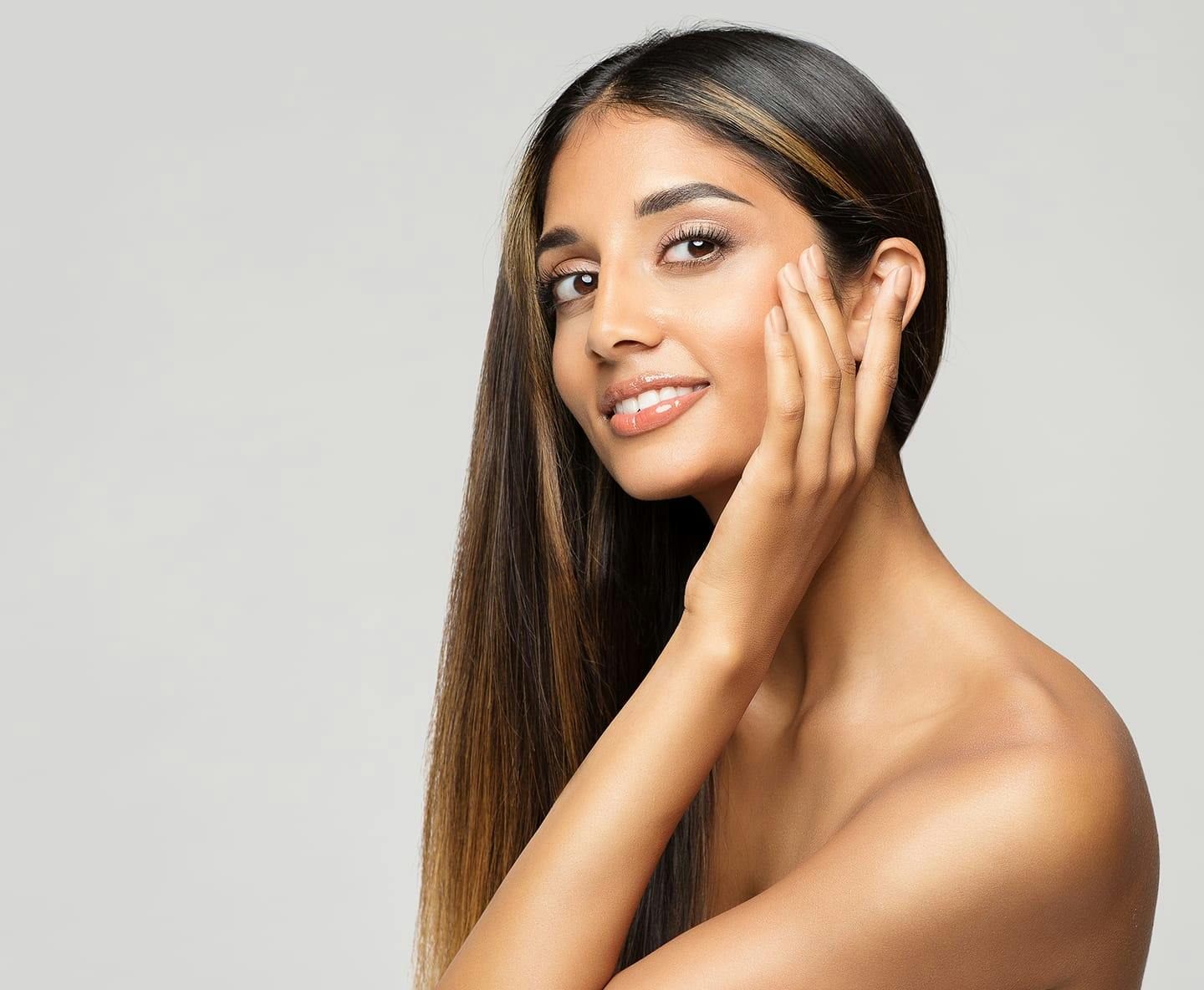 woman touching her face, with hair on one side of her head
