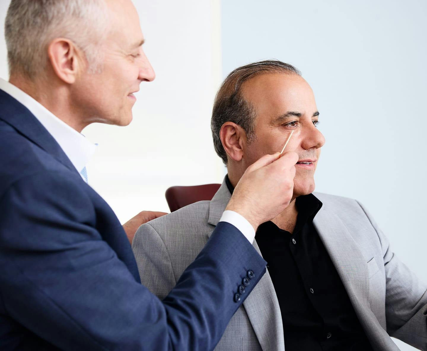 Dr. Fechner pointing to male patient's undereyes