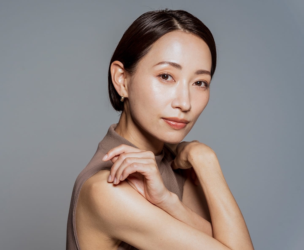 older woman with arms crossing and resting on her shoulders