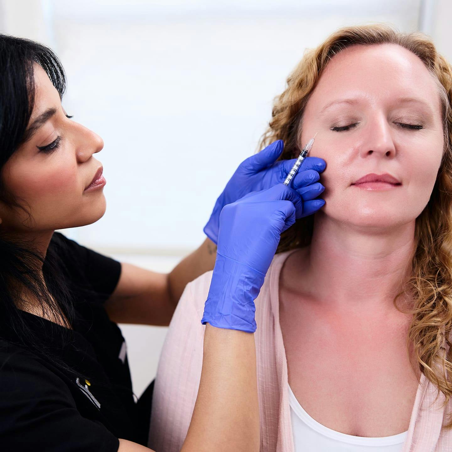 nurse injecting patient in her upper cheek