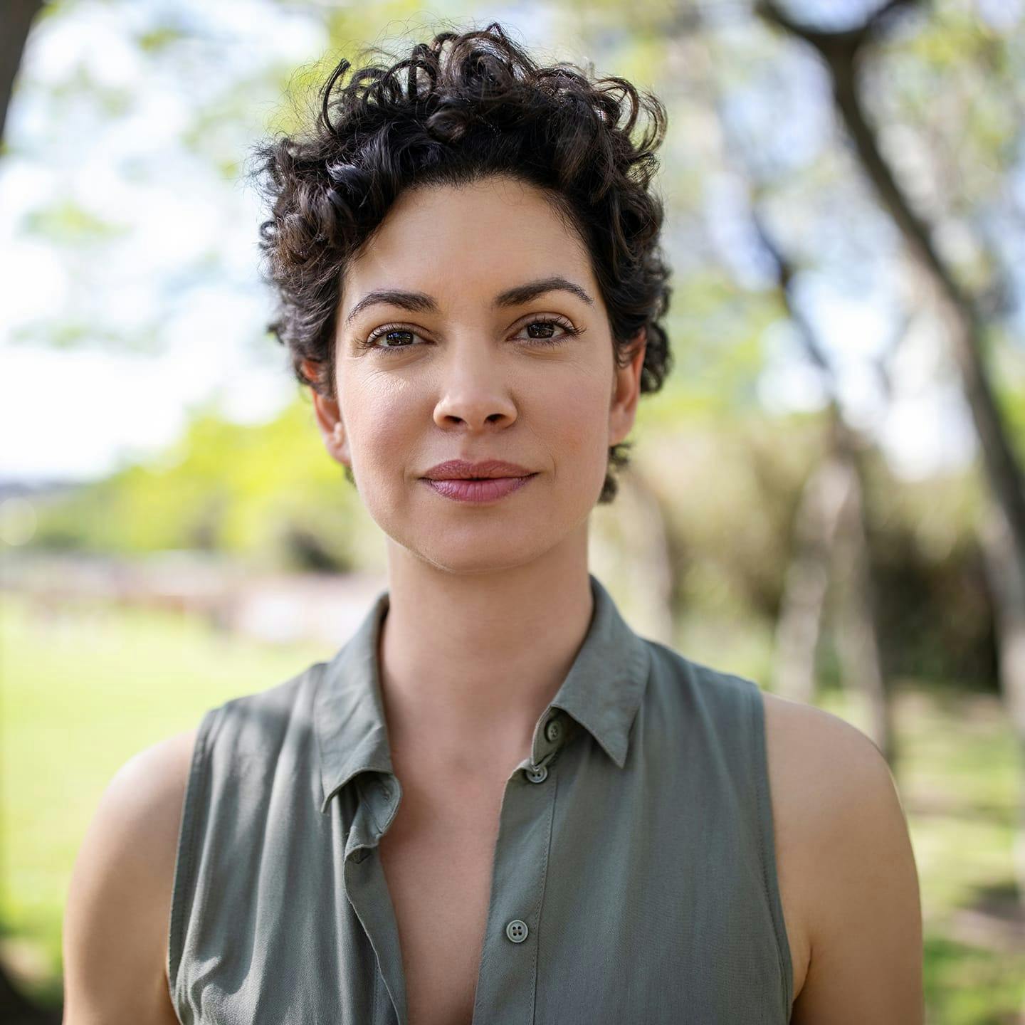 woman with short hair looking forward in green top