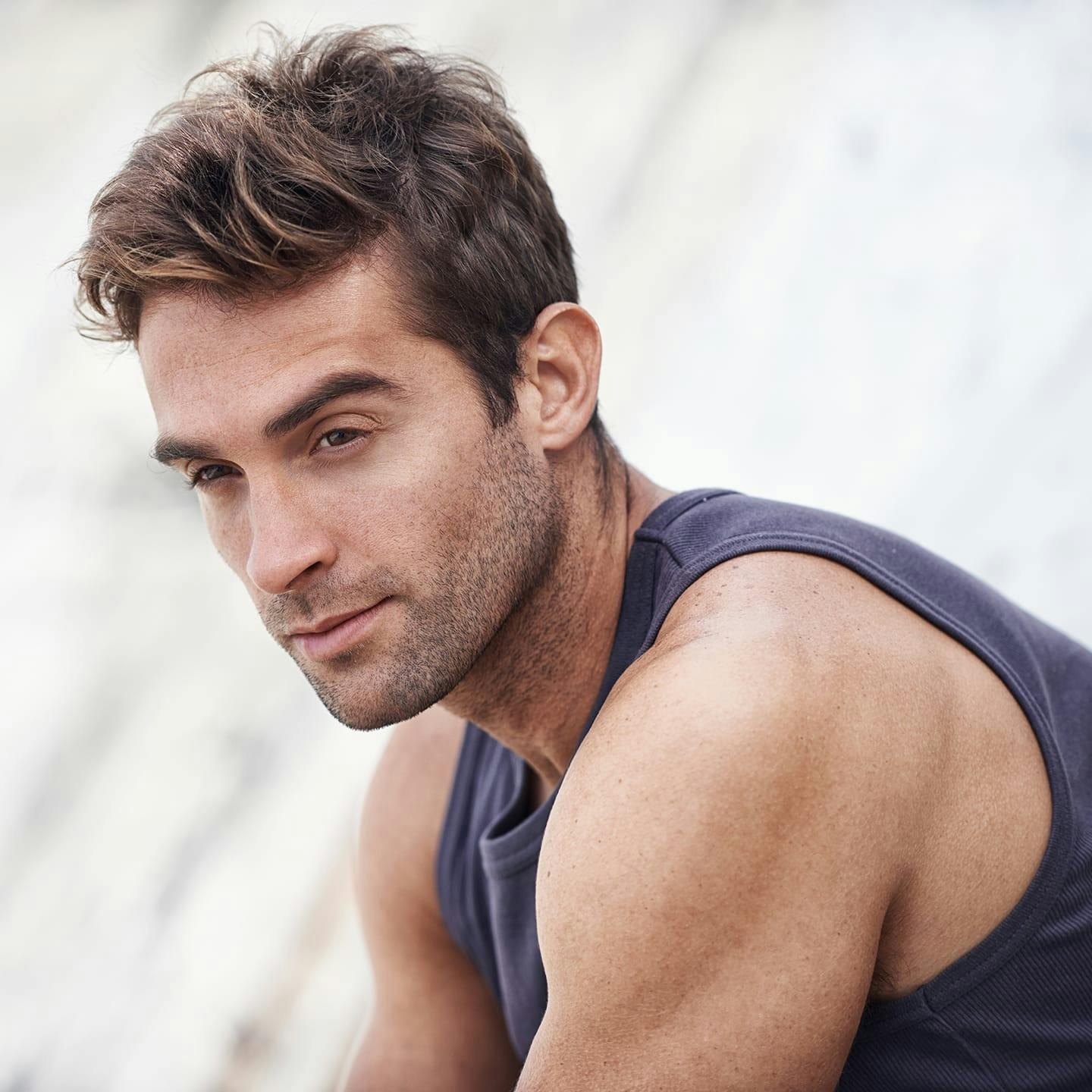 man in tanktop looking to the left