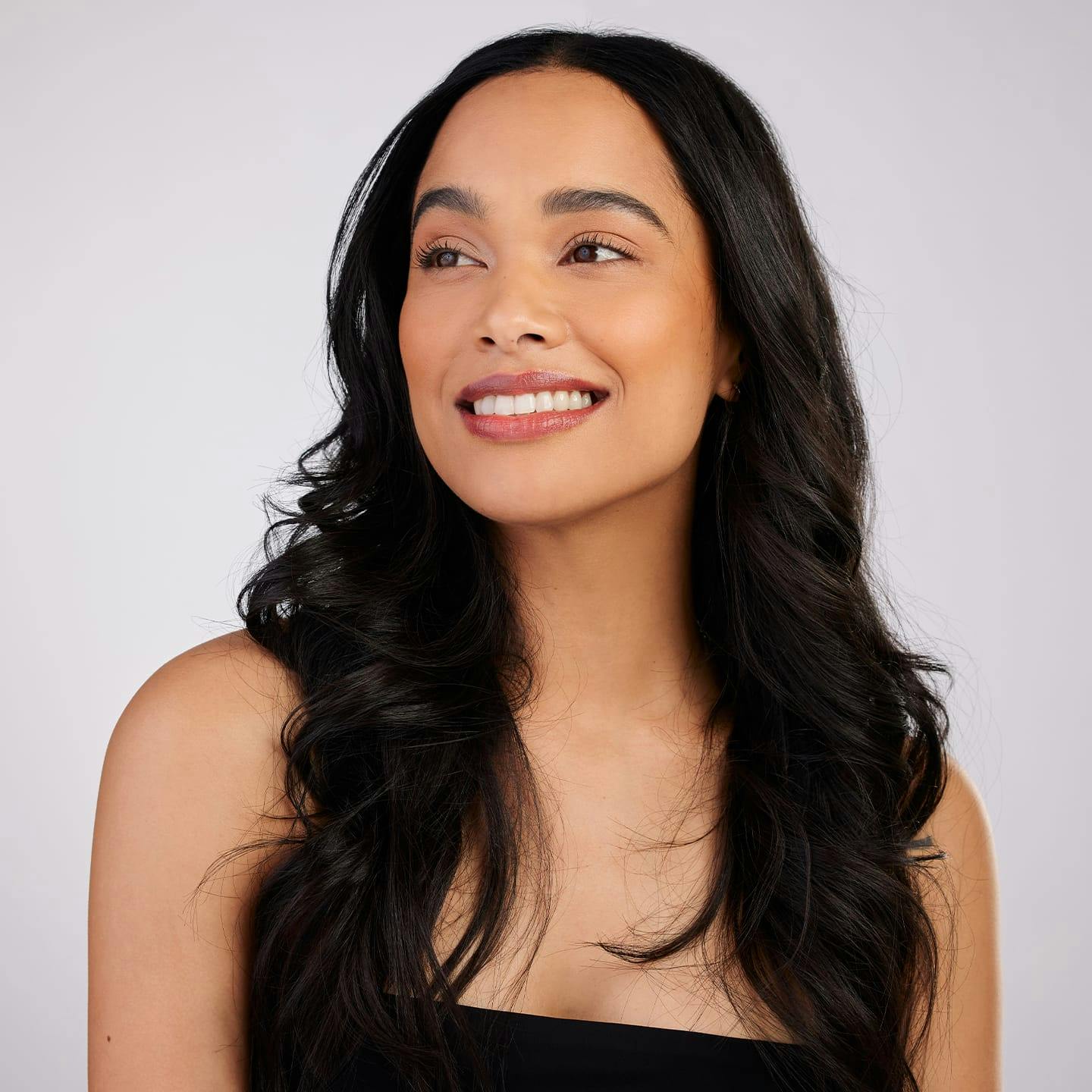 woman with long black hair smiling with black top on