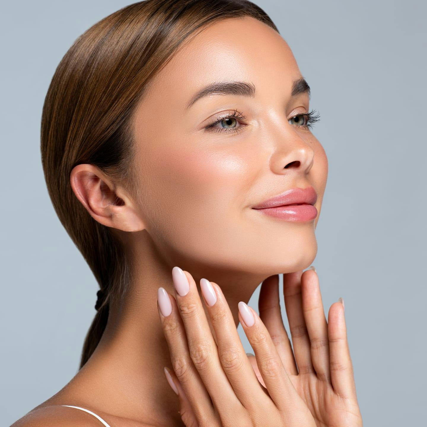 woman looking to the right with hands near her jaw