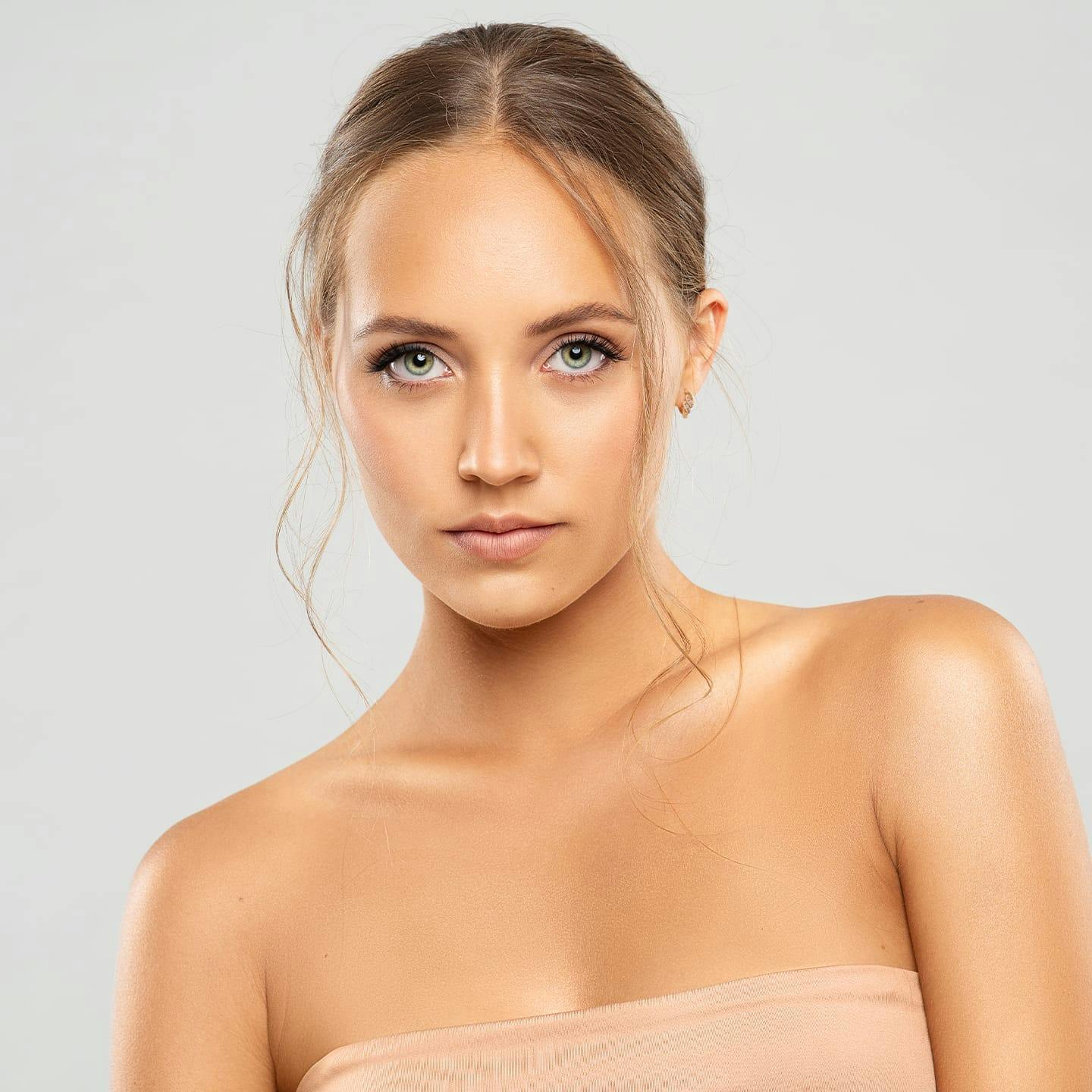 woman with hair up leaning to the left slightly with straight face