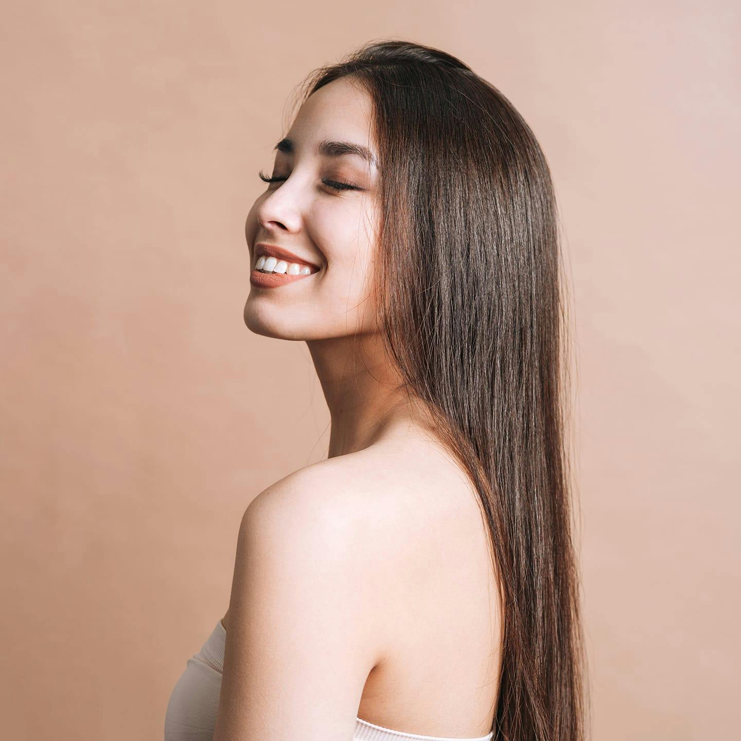 woman smiling and facing away with long straight hair