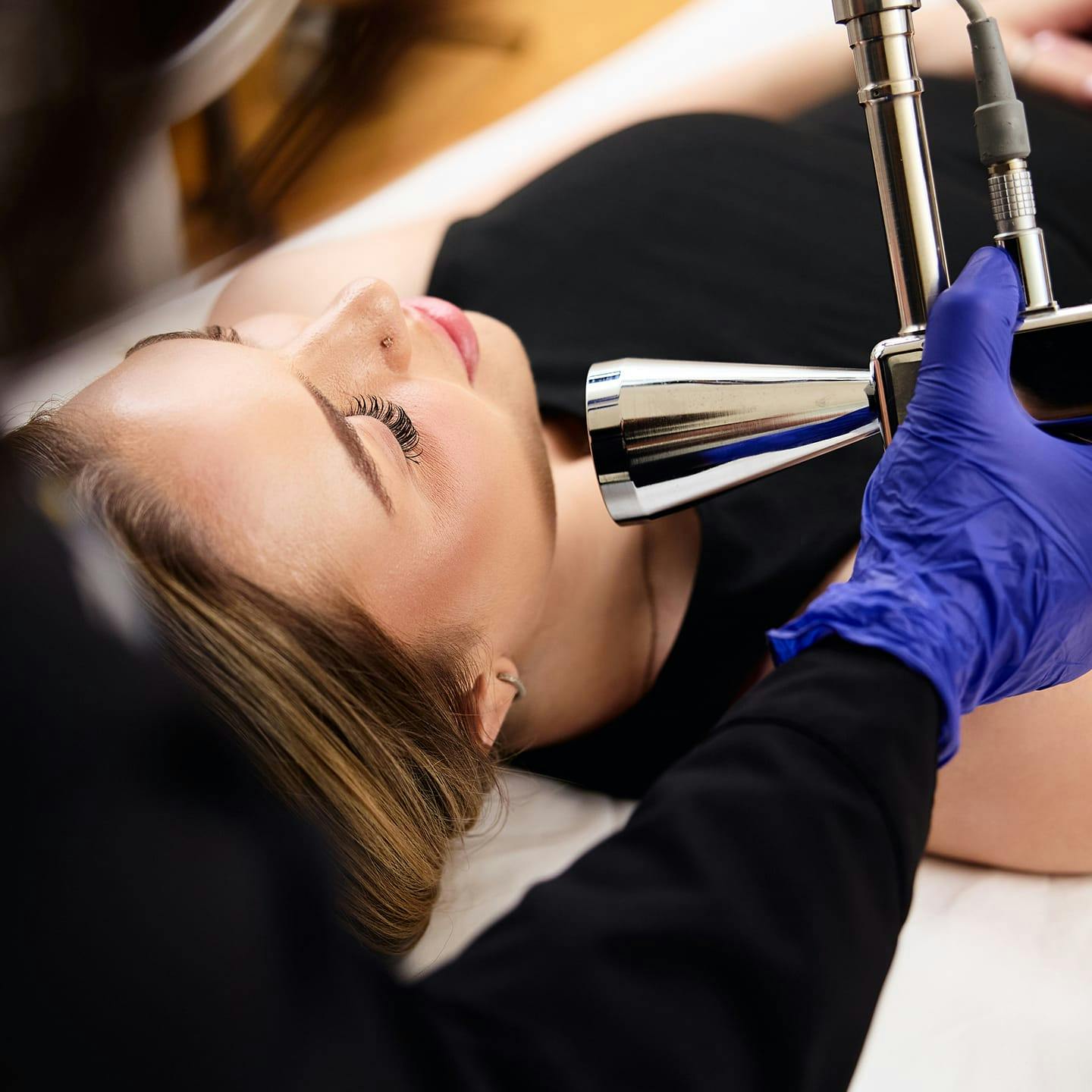 patient laying down while nurse holds machine near her face