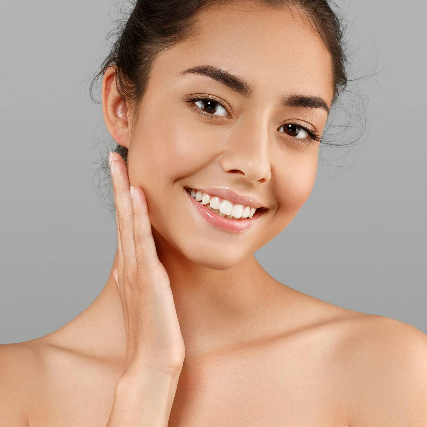 woman smiling with her hand near her ear