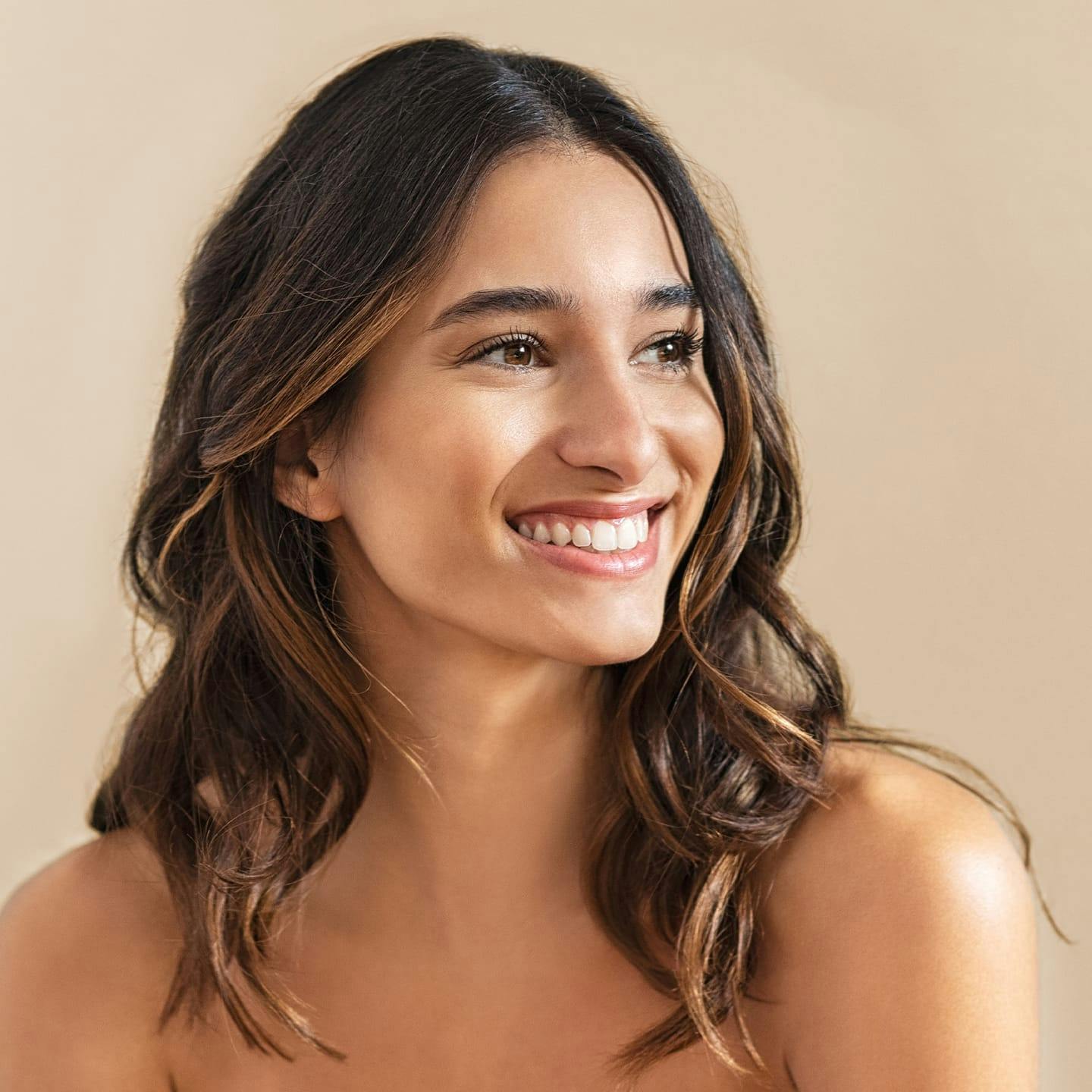 woman with brunette hair smiling to the right