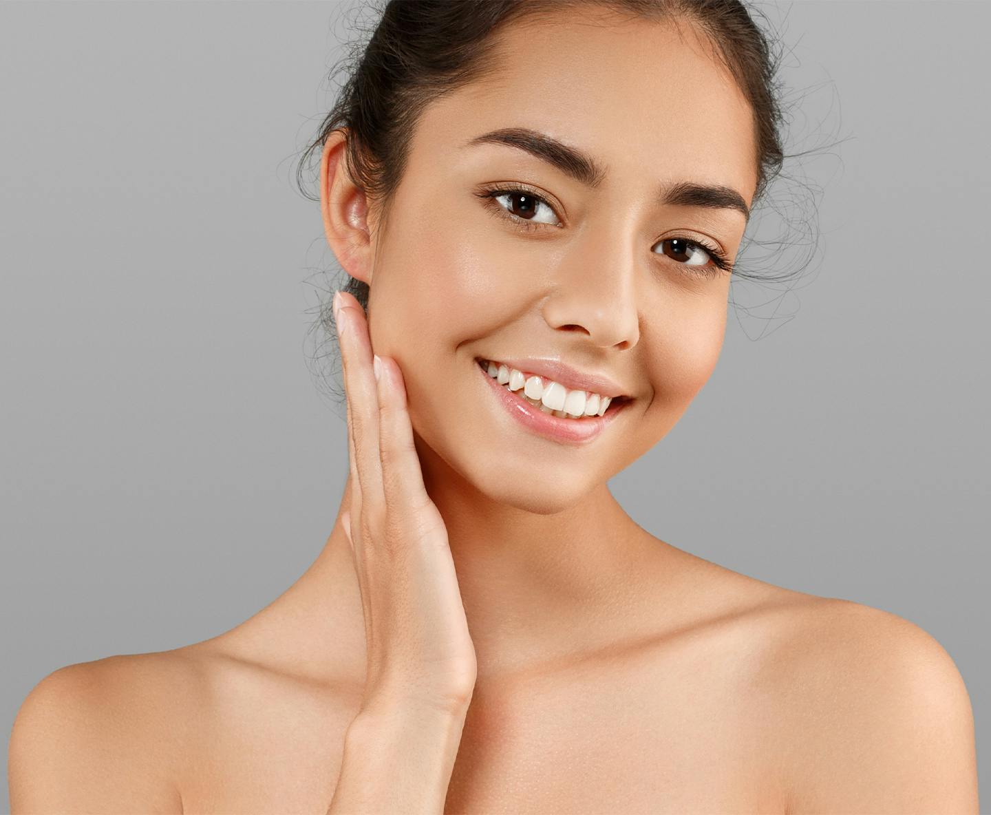 woman smiling and touching the side of her face