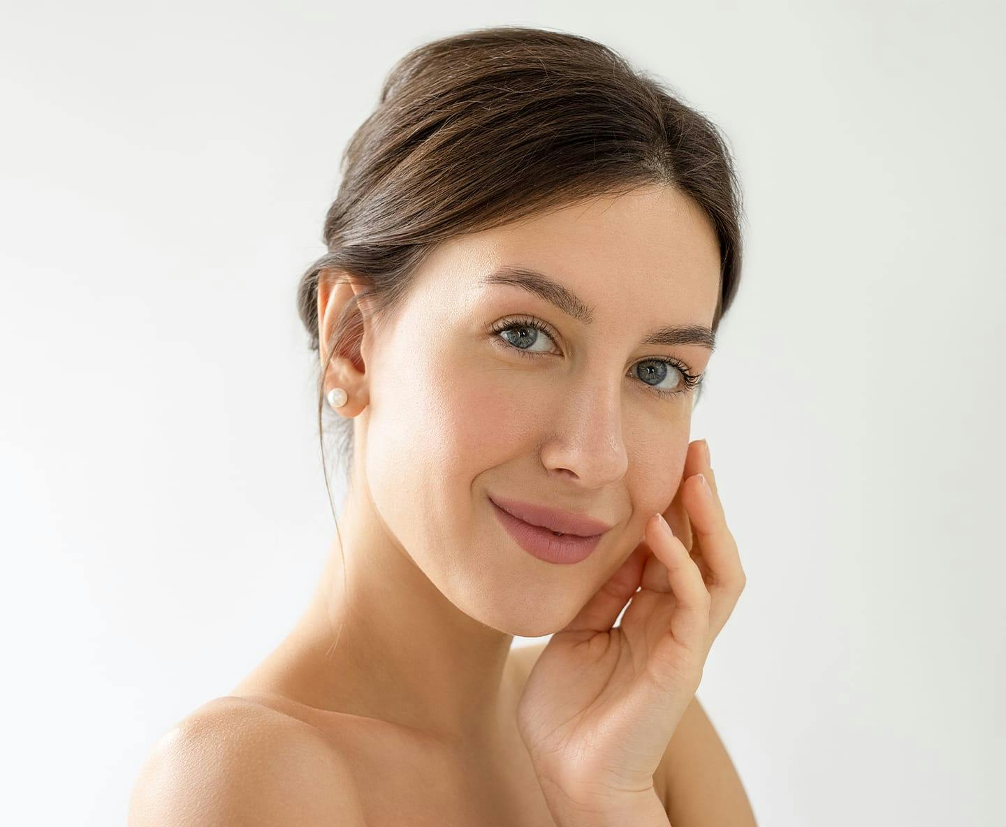 woman smirking and touching the side of her face