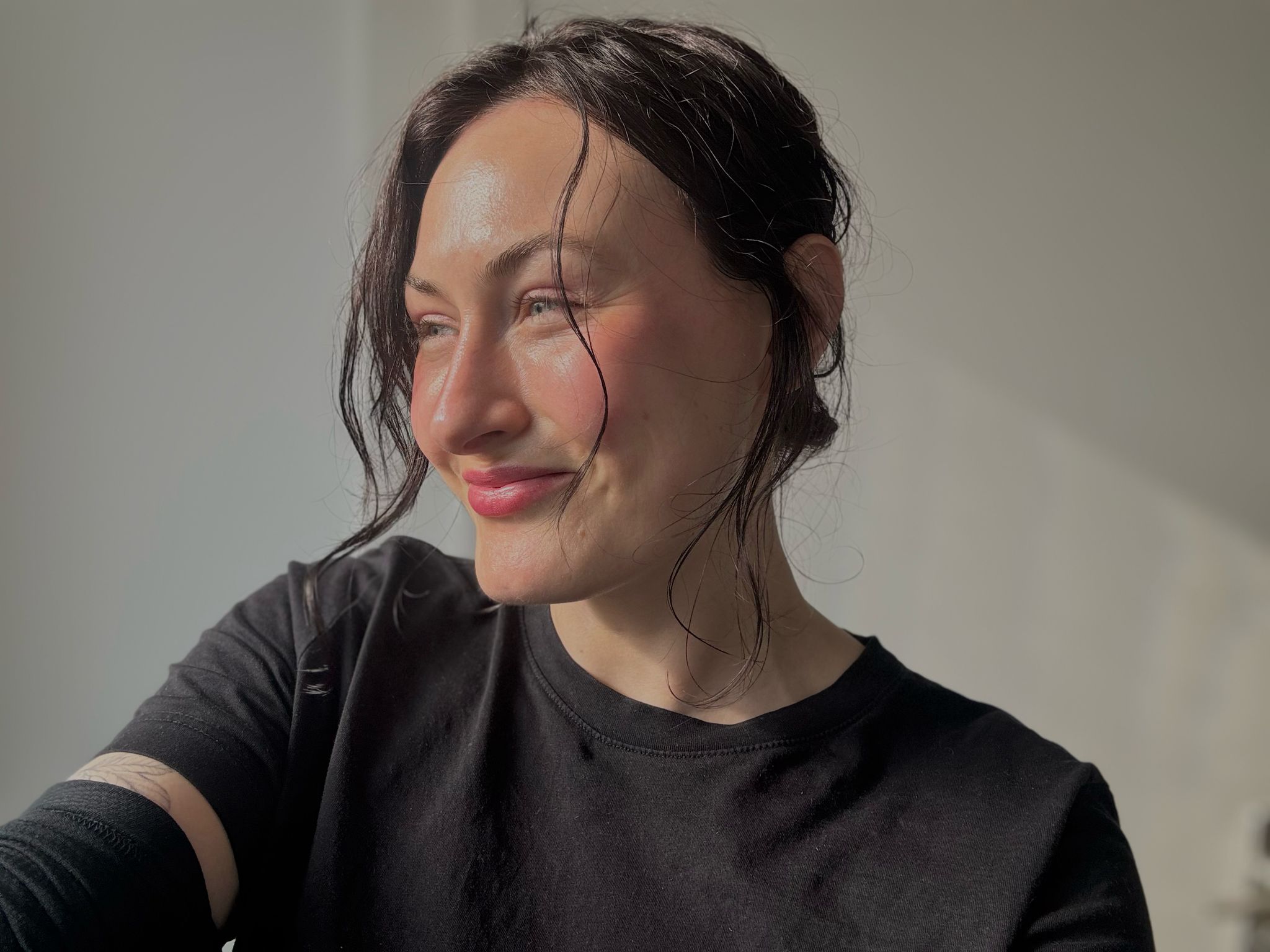 Lonneke kijkt glimlachend opzij met de zon op haar gezicht