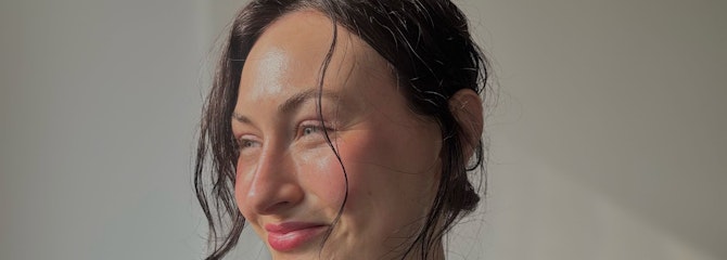 Lonneke kijkt glimlachend opzij met de zon op haar gezicht