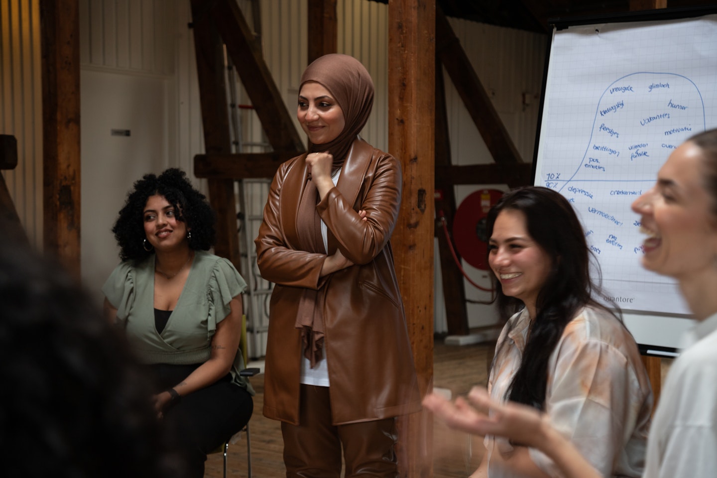 Jonge vrouw staat voor een groep jongeren die interactie hebben