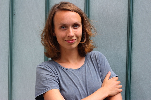 Glimlachende Hannah staat met haar armen zelfverzekerd over elkaar