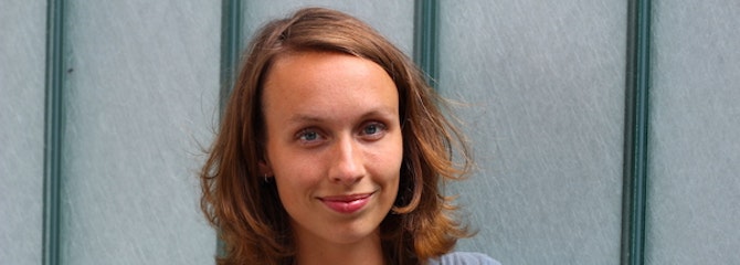 Glimlachende Hannah staat met haar armen zelfverzekerd over elkaar
