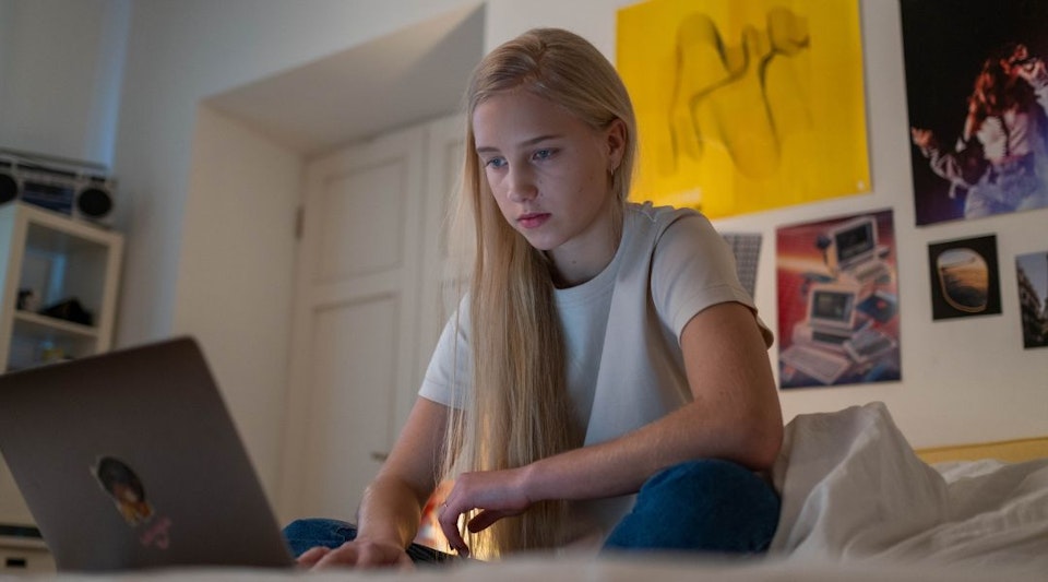 Meisje zit op haar bed en chat met het CSG