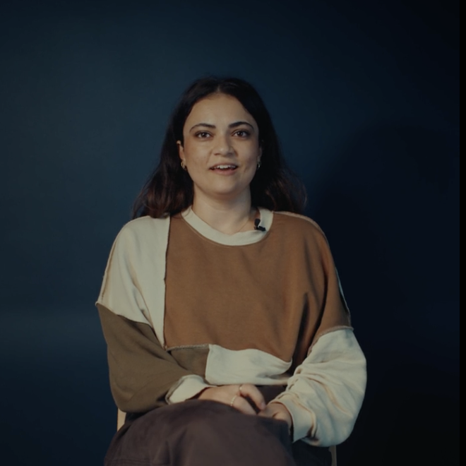 Hümeyra zit op een stoel, en kijkt in de camera, terwijl ze haar verhaal vertelt
