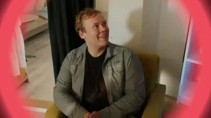 Man zit in stoel kijkt naar rechts en lacht