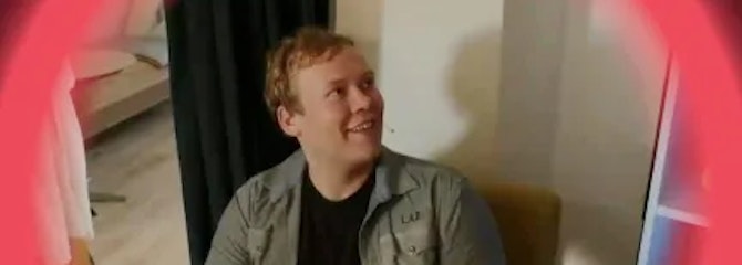 Man zit in stoel kijkt naar rechts en lacht