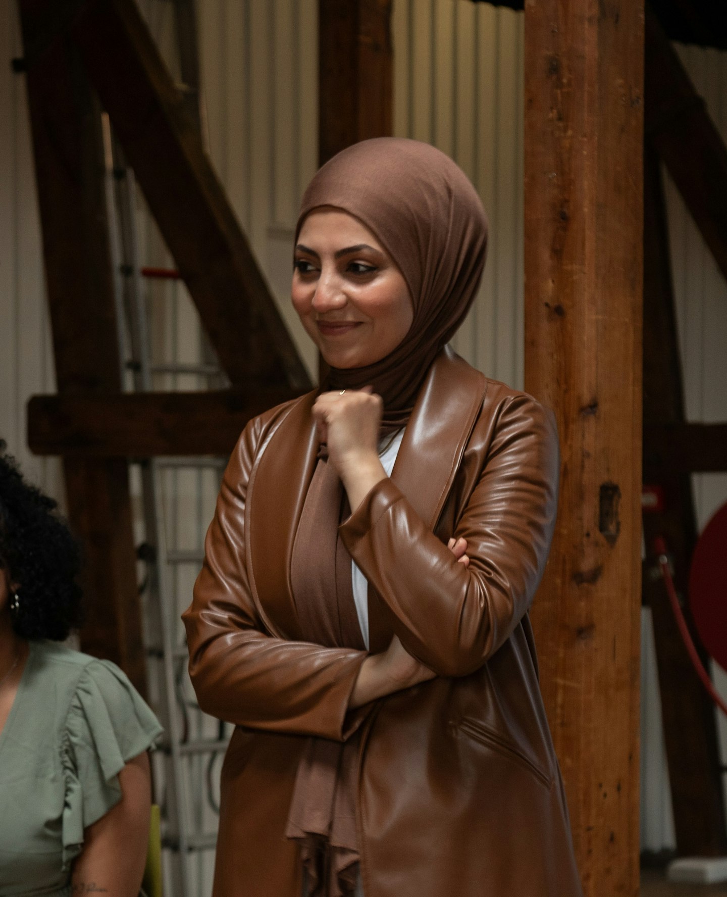 Glimlachende Halime staat zelfverzekerd en luistert naar een gesprek