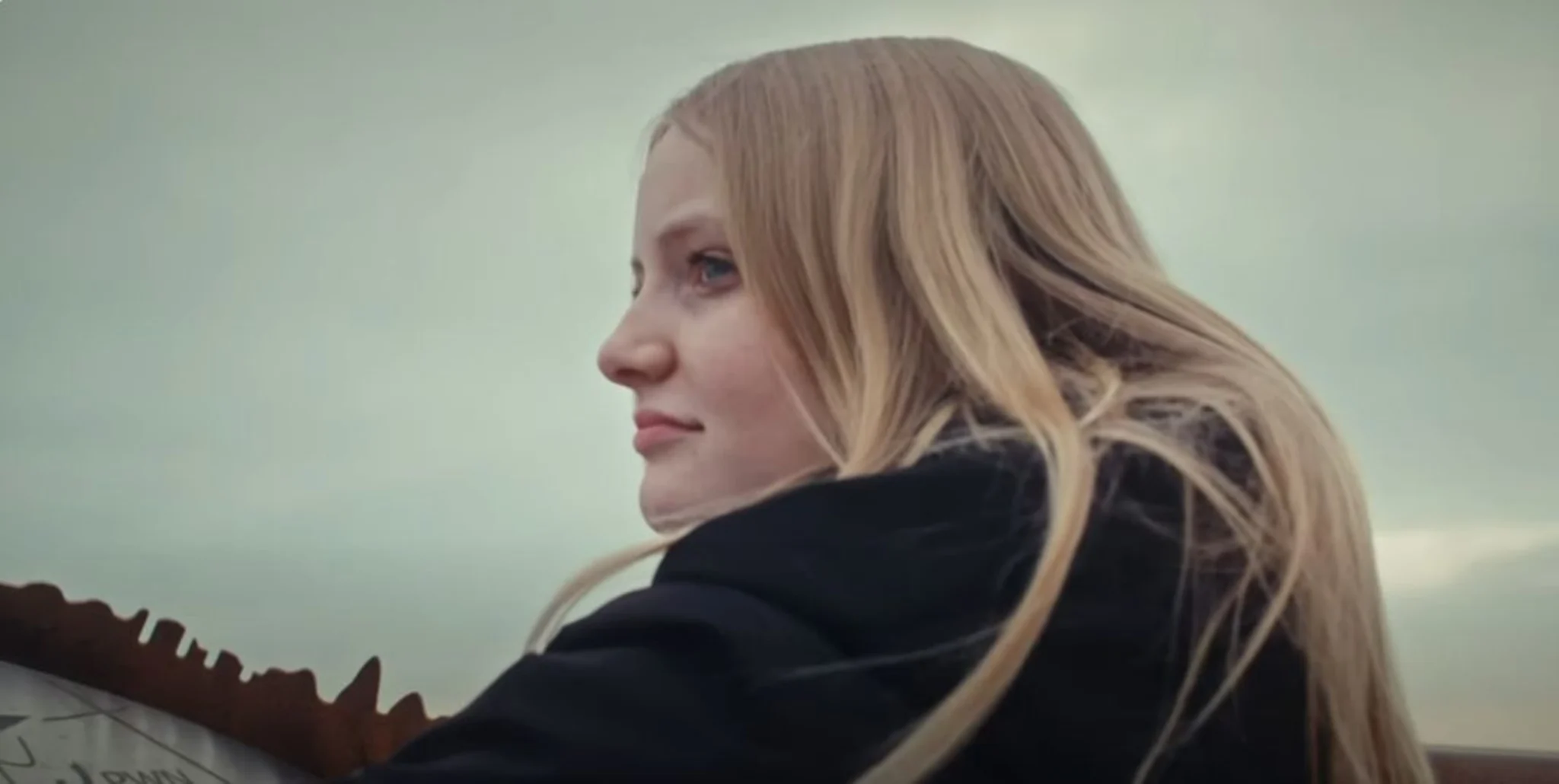 Indira staat buiten en kijkt in de verte