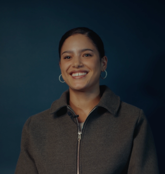 Louise kijkt lachend in de camera, terwijl ze haar verhaal vertelt