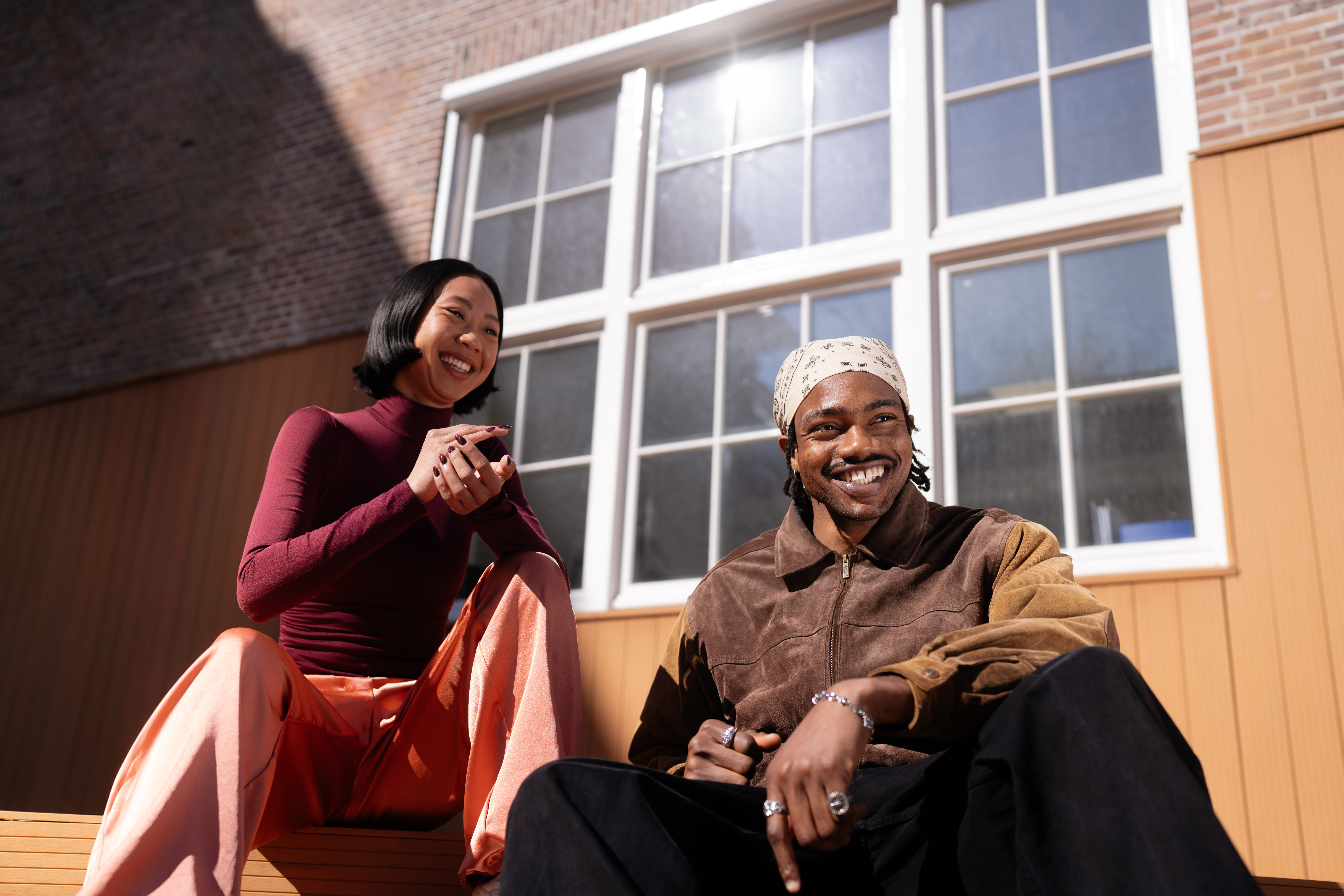 Twee vrienden zitten buiten, lachen en genieten samen van een zonnige dag