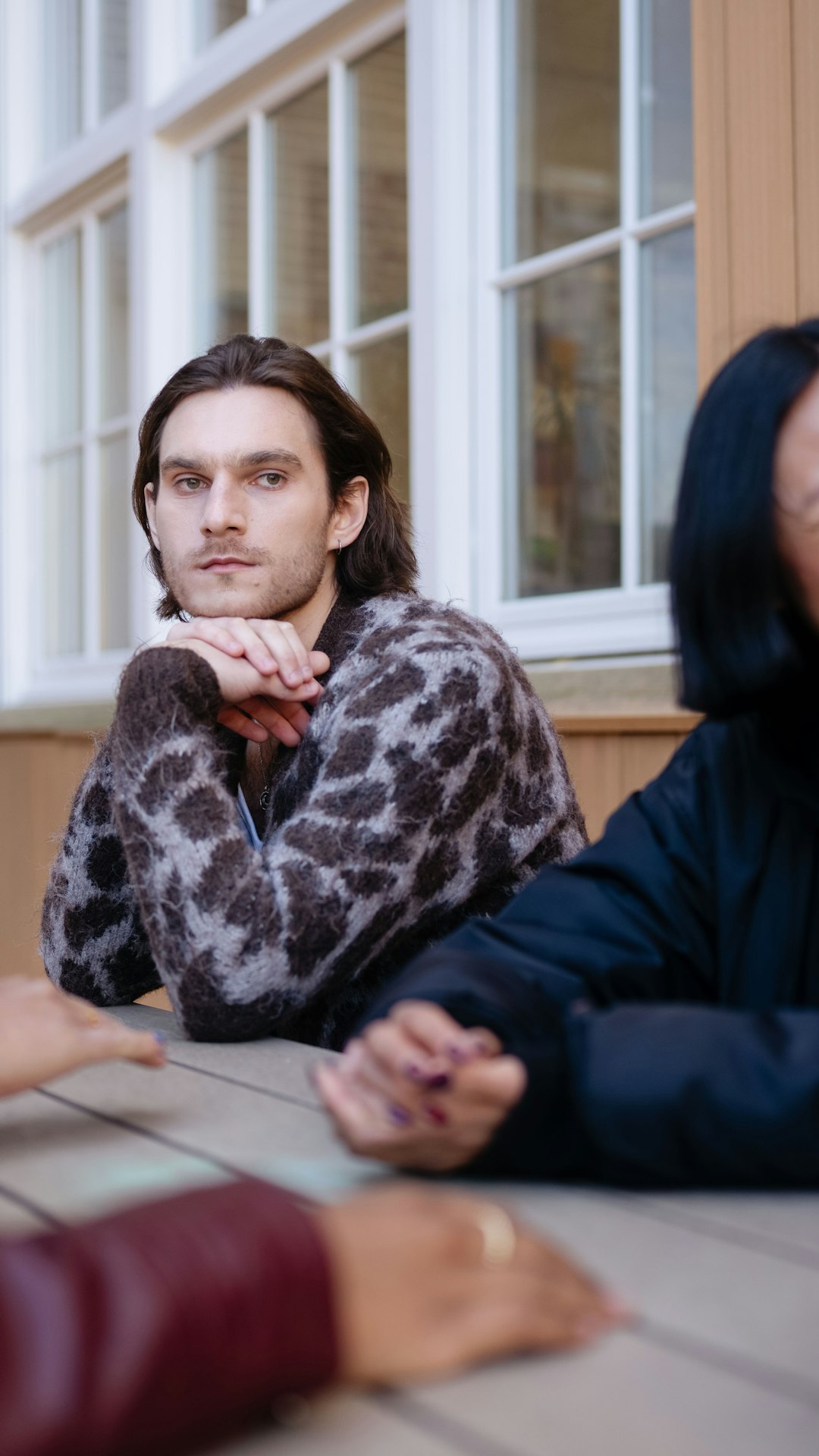Man is alleen in gedachten verzonken aan een picknicktafel met gezellig kletsende vrienden