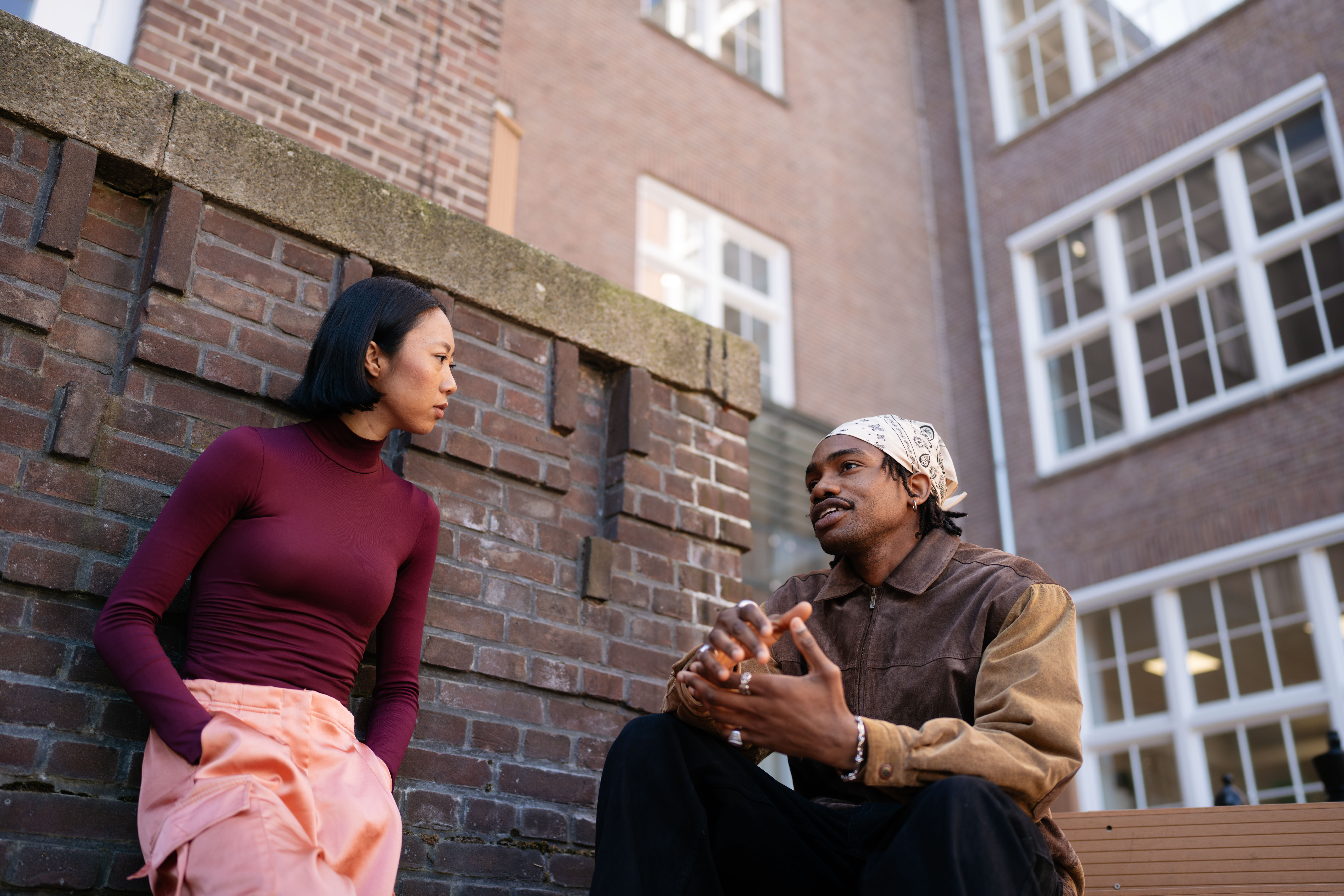 Twee personen voeren buiten een betekenisvol gesprek voor een stenen muur