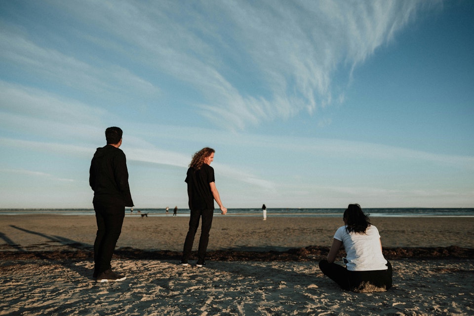 Drie jongeren op het strand