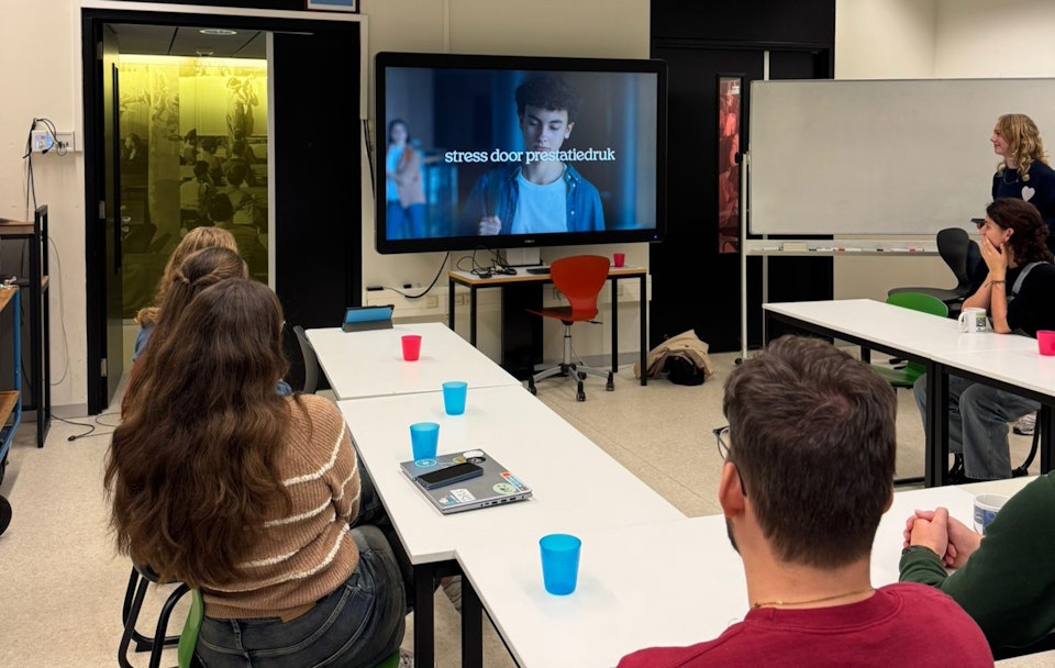 Klaslokaal waarin jongeren naar een video van In je bol kijken op een beeldscherm