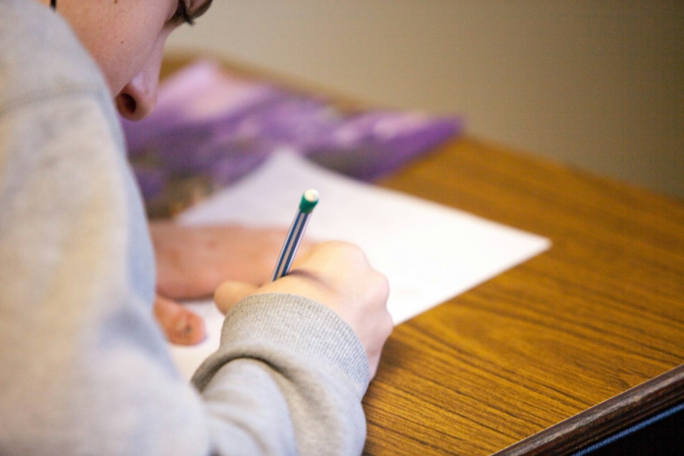 scholier vult examenblad in