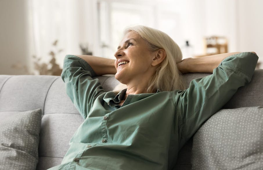 woman laying back on couch with arms holding her head