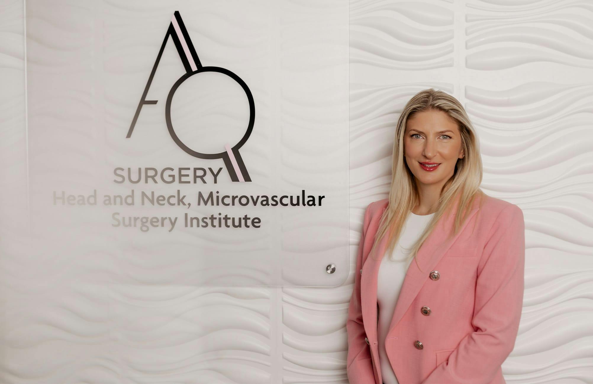 Dr. Quimby standing next to AQ Surgery logo