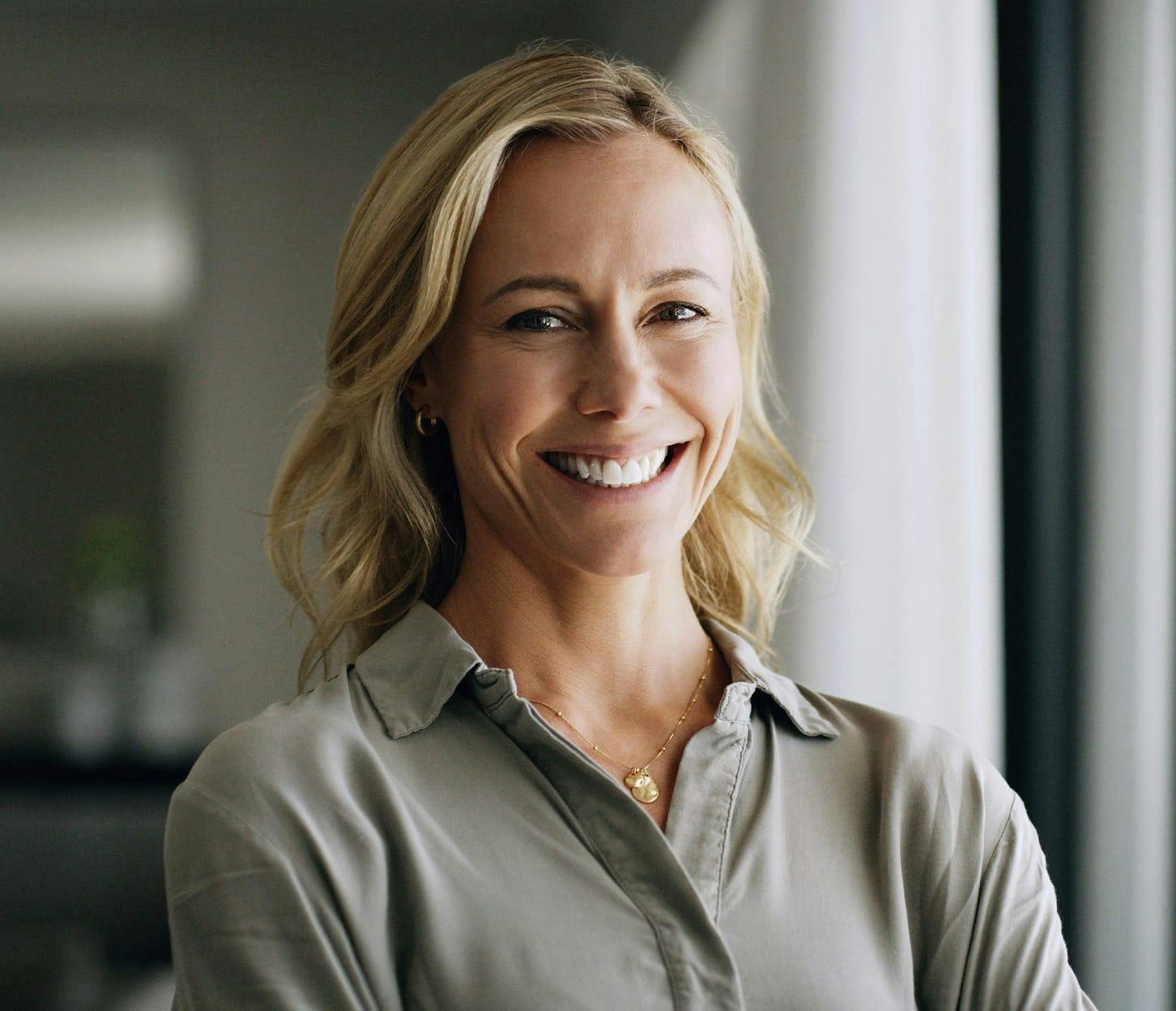 woman smiling in beige shirt