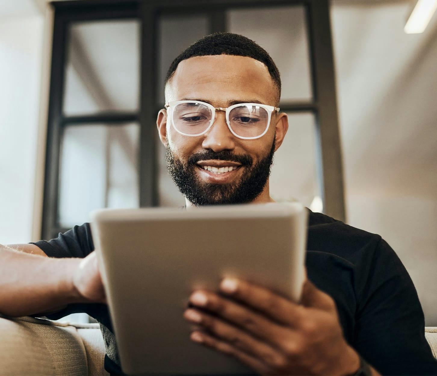 man in white glasses on an ipad