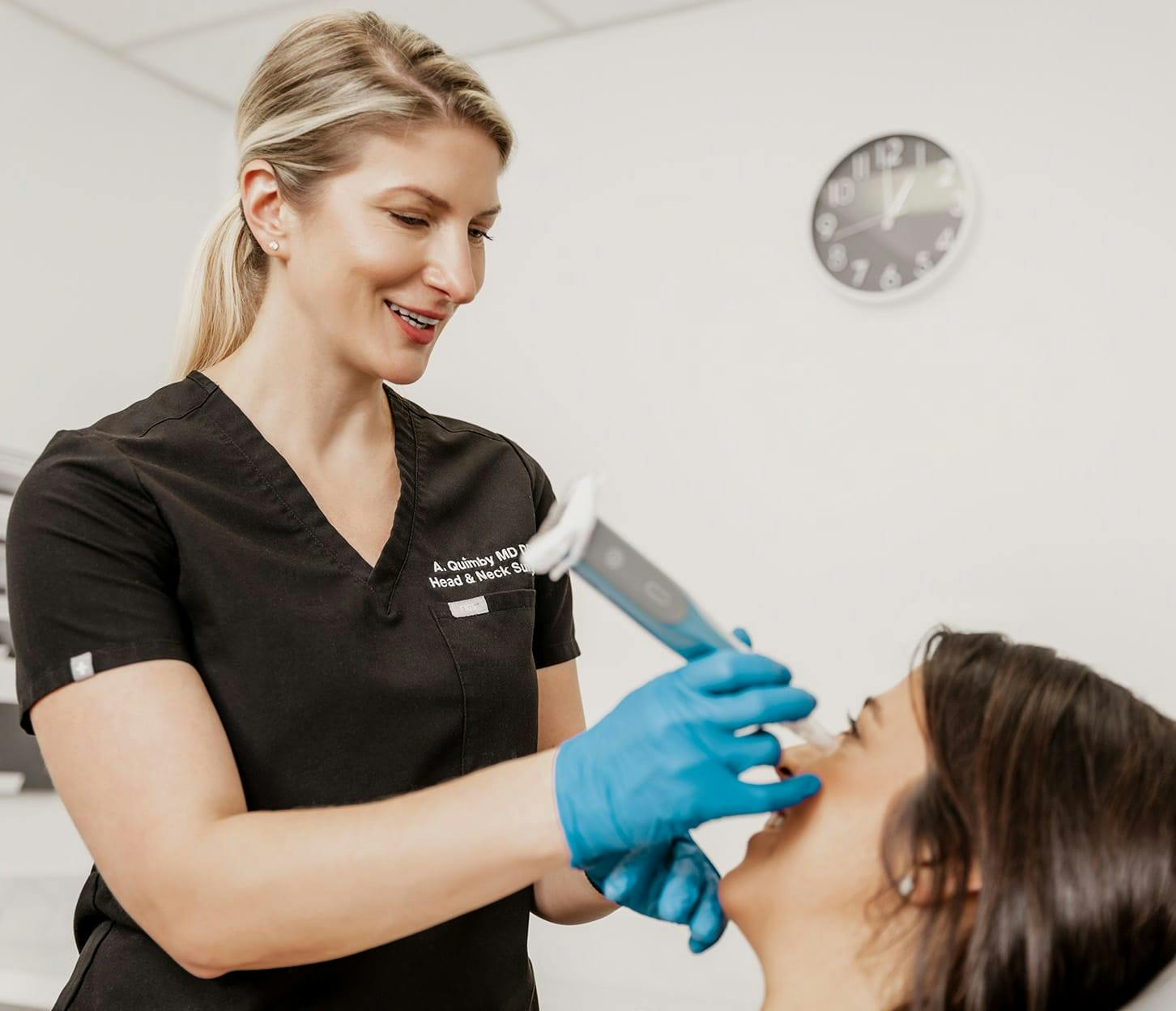 Dr. Quimby holding machine against client's cheek