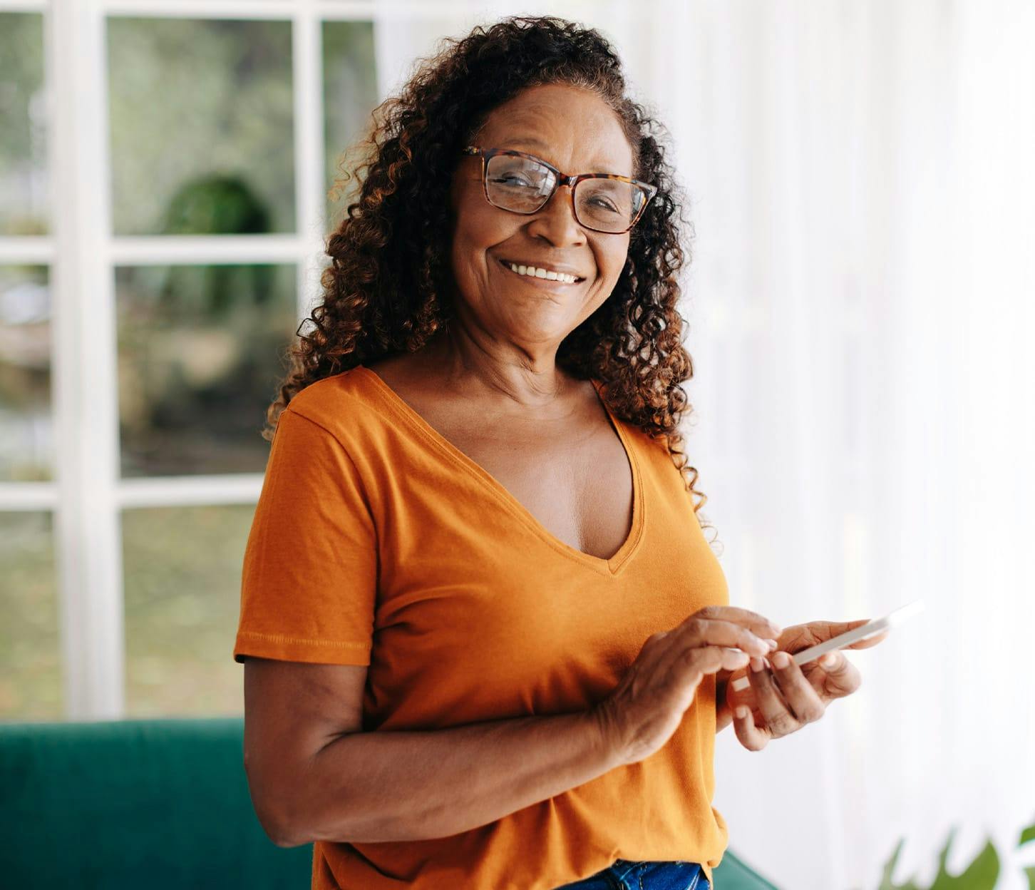 woman smiling while holding her phone