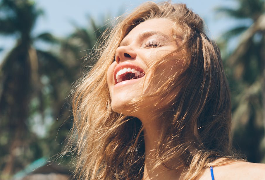 Woman laughing as her hair blows in the breeze