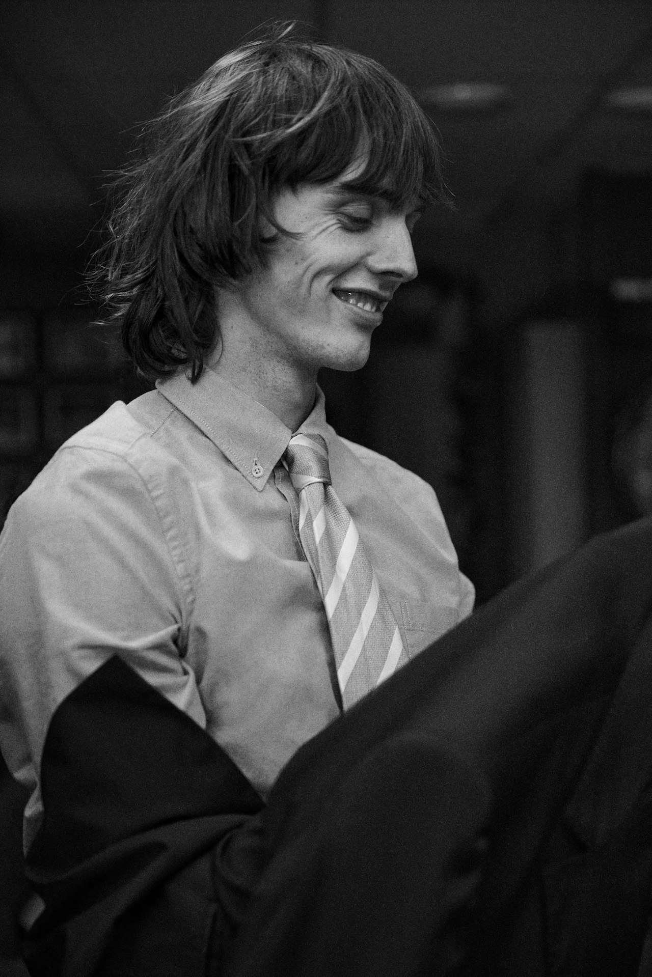 black and white photo of a young man looking away and smiling