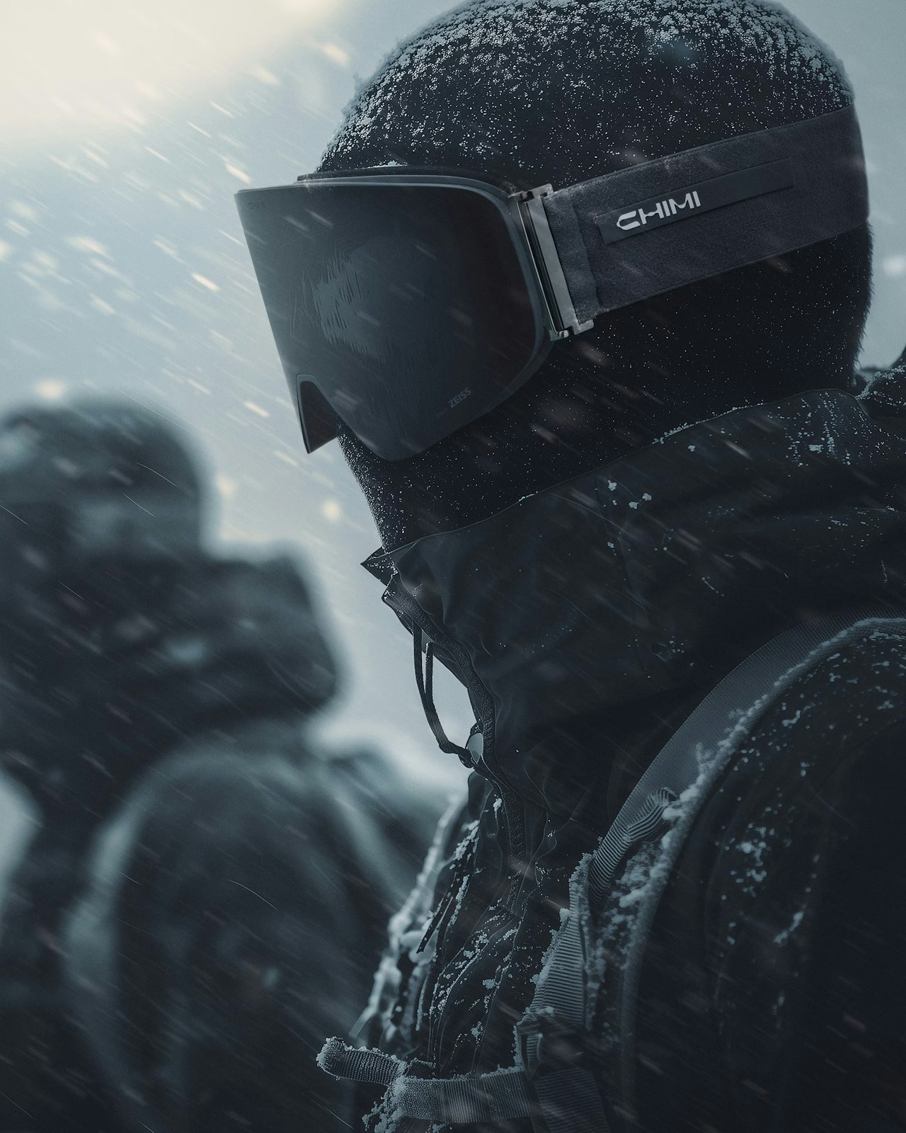 Person in snow gear and goggles faces snowy weather, another figure in background.