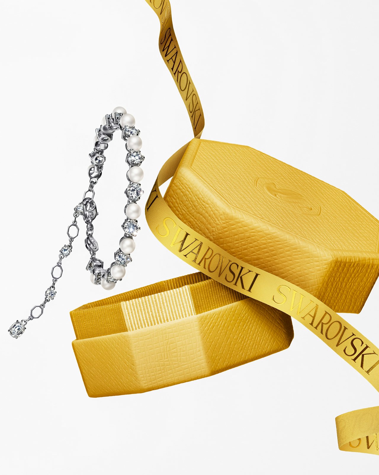 A silver and pearl bracelet with yellow Swarovski box and ribbon.
